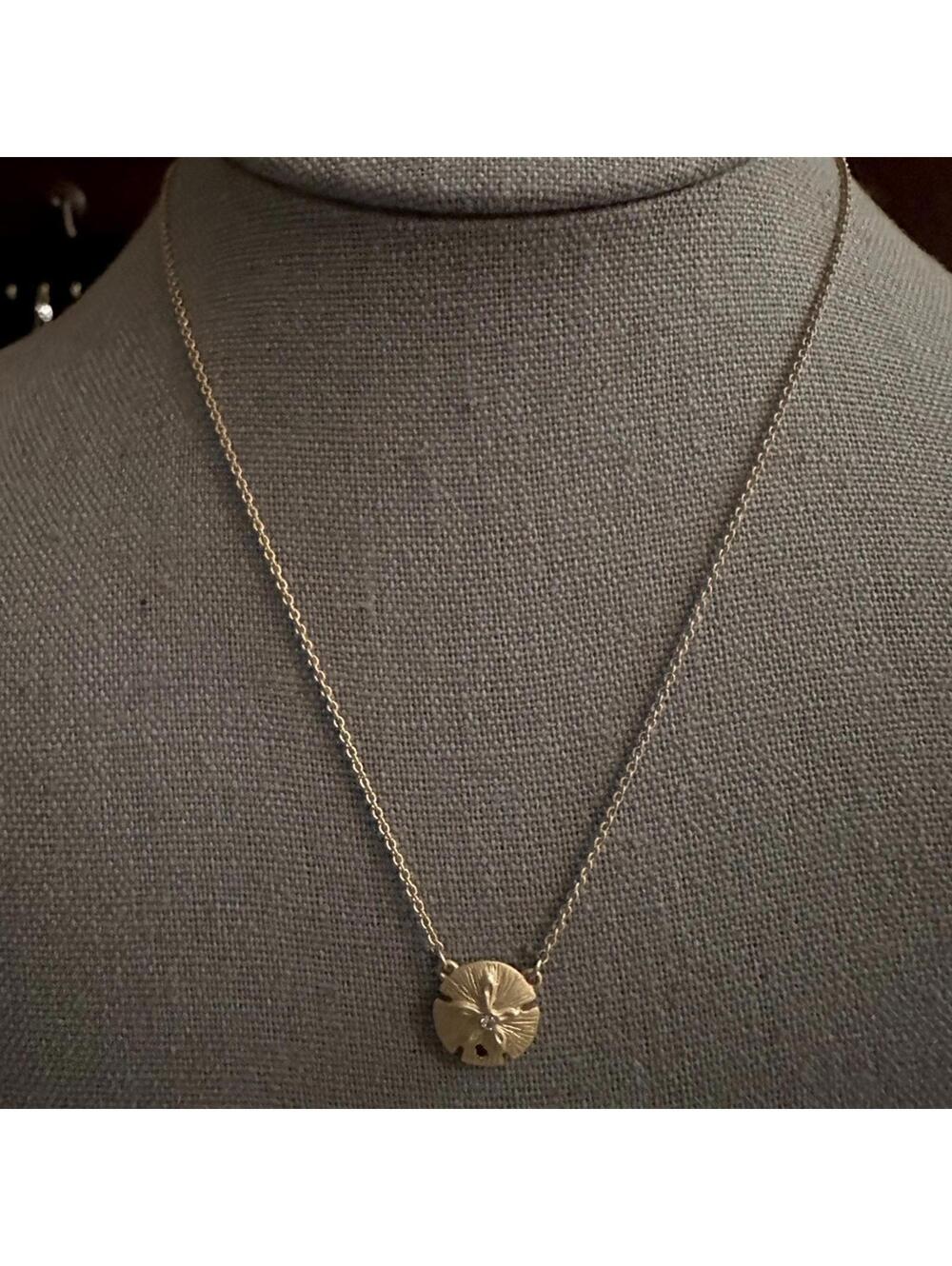 Vintage gold necklace with sand dollar charm.